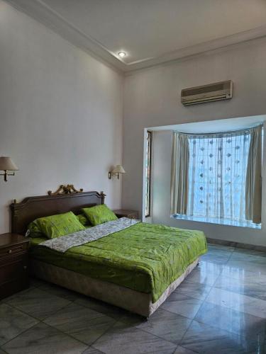 a bedroom with a bed and a large window at Kuca Cigadung in Bandung