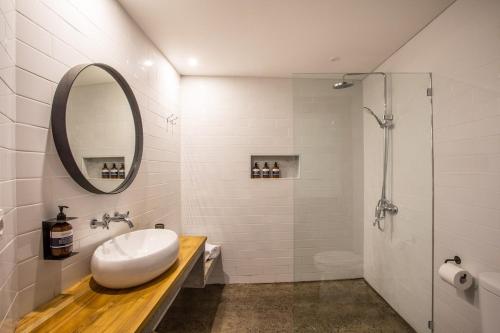 a bathroom with a sink and a mirror and a shower at The Echo Studios HUGE 100m to beach 1 in Badung