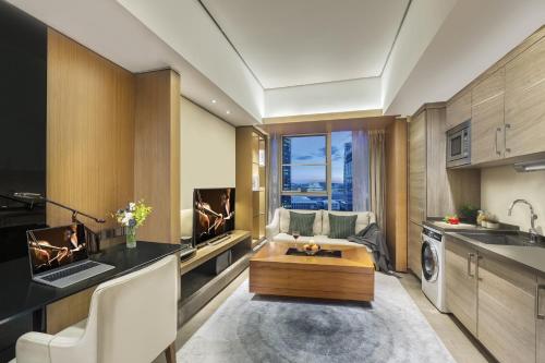 a kitchen with a couch and a table in a room at Ascott IFC Guangzhou in Guangzhou