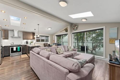 a living room with a couch and a kitchen at Seaside Haven -Hot Tub with Oceanfront View in Port Renfrew