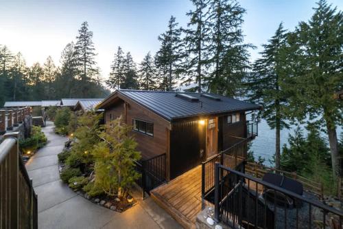 a cabin on a deck with a view of the water at Seaside Haven -Hot Tub with Oceanfront View in Port Renfrew