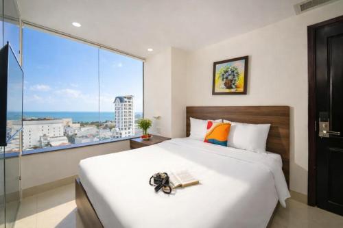 a bedroom with a large bed and a large window at Mira Grand Hotel Quy Nhơn in Quy Nhon