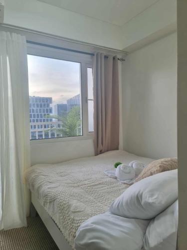 a bedroom with a bed and a large window at 963 D shore 1 in Manila