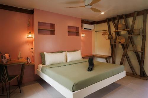 a bedroom with a bed with a black cat sitting on it at Bamboo Jungle Villa's in El Nido