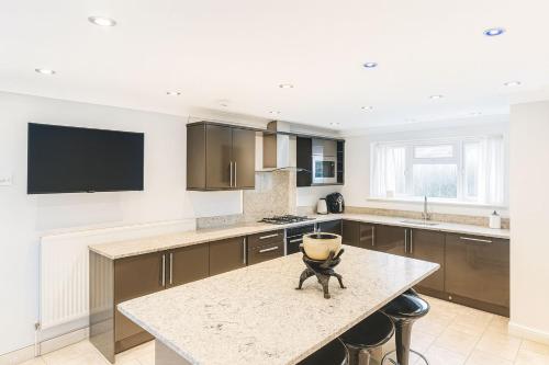 a kitchen with a table and a tv on the wall at Private Room Near Excel London & City Airport Free Parking Available & WiFi in North Woolwich