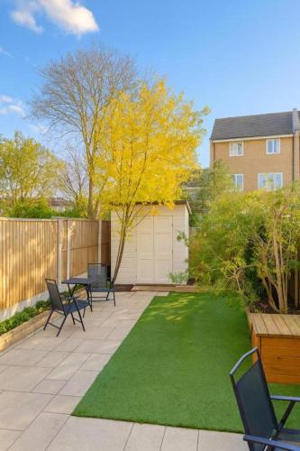 a backyard with a table and chairs and a lawn at Private Room Near Excel London & City Airport Free Parking Available & WiFi in North Woolwich