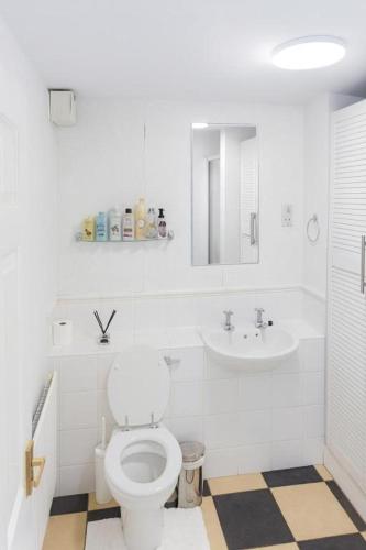 a white bathroom with a toilet and a sink at Private Room Near Excel London & City Airport Free Parking Available & WiFi in North Woolwich
