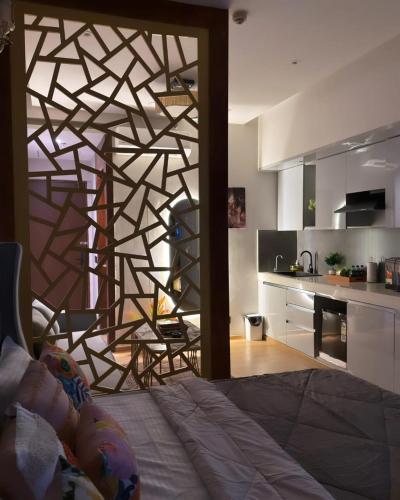 a bedroom with a wooden wall with a kitchen at Galaxy Blue sapphire Plaza Square Residency in Ghaziabad