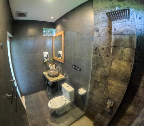 a bathroom with a toilet and a sink at Swell Hotel, Pool Bar & Restaurant in Tanah Lot