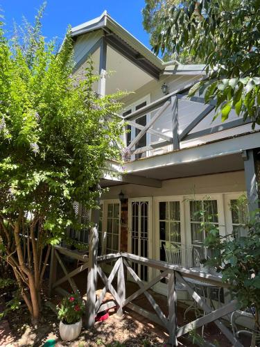 a house with a wooden fence in front of it at Banksia Cottage in Perth Hills in Perth