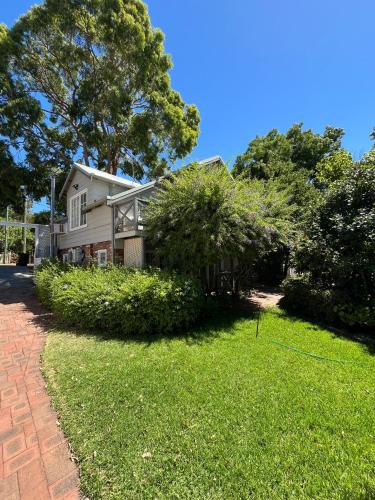 a house with a brick driveway in front of a yard at Banksia Cottage in Perth Hills in Perth