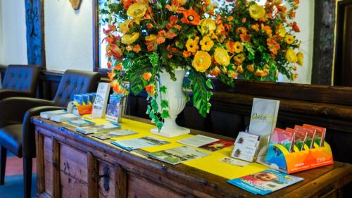 a table with a vase with flowers on it at Hotel Astoria in Leukerbad