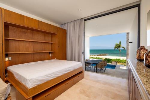 a bedroom with a bed and a view of the ocean at Beachfront townhouse TH03A in Cruz de Huanacaxtle