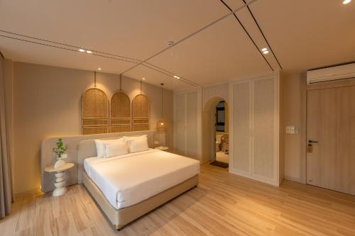 a bedroom with a large white bed in a room at Emerald Boutique Hotel Phú Quốc in Phú Quốc