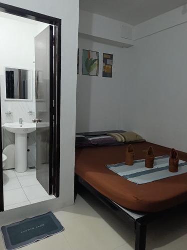 a bedroom with a bed and a bathroom with a sink at Chelle's apartelle-inn in El Nido