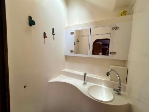 a white bathroom with a sink and a mirror at Croisière dans les îles de Krabi in Ao Nang Beach