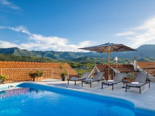 a swimming pool with chairs and an umbrella at Villa Vito - with heated pool, whirlpool, gym in Šarići