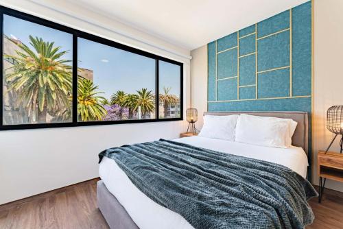 a bedroom with a bed and a large window at Narvarte Apartments by Escajal Homes in Mexico City