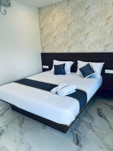 a large bed with two pillows on top of it at Fenna Resort And Spa, coorg in Kushālnagar