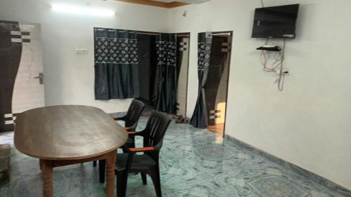 a room with a table and chairs and a television at Sujata Buddha Homestay in Bodh Gaya