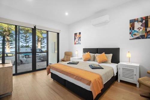 a bedroom with a king sized bed and a balcony at Harborview Modern Studio 11F in Victor Harbor