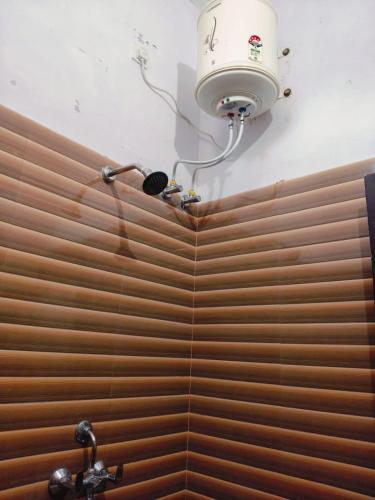 a bathroom with a shower with a light on the wall at Corbett Bungalow Stay- Private Garden Stay Near Jim Corbett in Rāmnagar