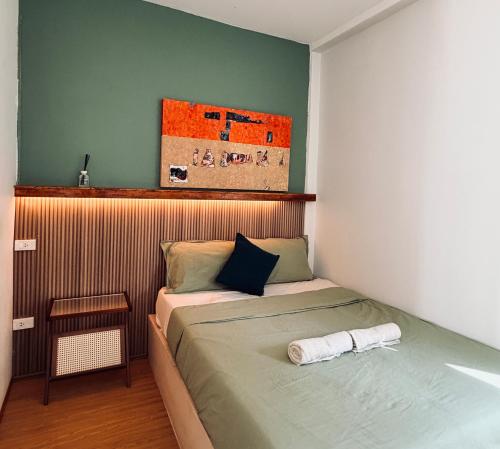 a small bedroom with a bed with aroll at Happiness Hostel Private room in Phra Ae beach