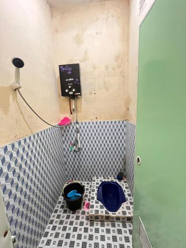 a small bathroom with a blue toilet in the corner at DIENG CAKRAWALA CABIN Tambi Syariah in Kejajar