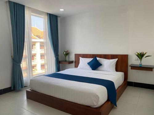 a bedroom with a large bed with a large window at HomeStore Apartment in Siem Reap