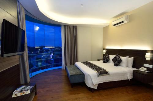 a hotel room with a bed and a large window at Holiday Villa Hotel & Suites Kota Bharu in Kota Bharu