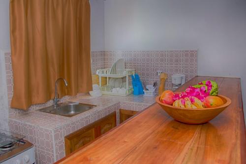Una cocina con un bol de fruta en la encimera. en Hotel-Residence Au Sable Blanc, en Madirokely