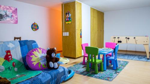 a childs play room with a table and chairs at Hotel Astoria in Leukerbad