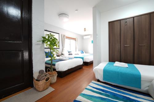 a bedroom with two beds and a couch at Retreat Ginoza in Ginoza