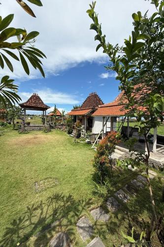 a yard with a house and a gazebo at Bali Eco Living Yoga Healing Meditation and Retreat Center in Denpasar