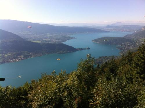 a view of a lake with kites flying in the sky at Le Pré du Lac in Saint-Jorioz