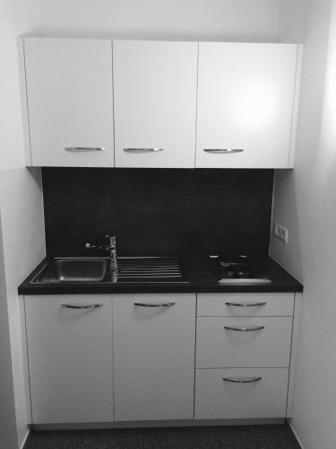 a kitchen with white cabinets and a sink at Beim Dorner in Schenna
