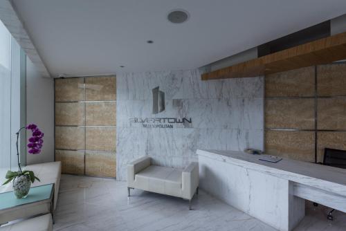 a lobby with a reception desk and a chair at Naki Suites @ Silvertown in Phnom Penh