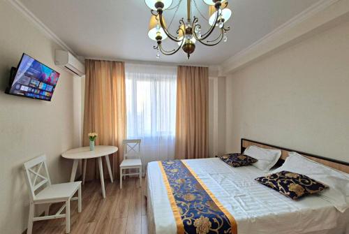 a bedroom with a bed and a table and a chandelier at Apartments Chisinau in Chişinău