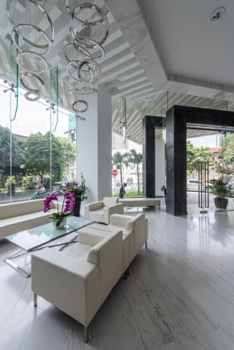 a lobby with white furniture and large windows at Naki Suites @ Silvertown in Phnom Penh