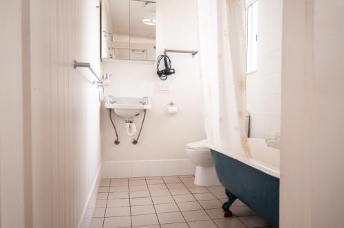 a bathroom with a sink and a toilet and a tub at Eco Retro Aldinga Beach House in Aldinga Beach