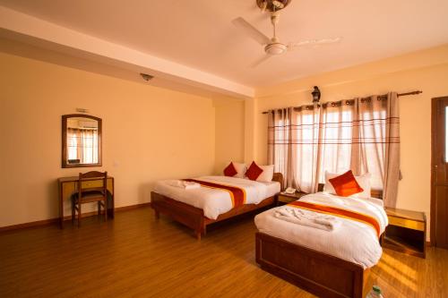 a bedroom with two beds and a window at Hotel Pokhara View in Pokhara