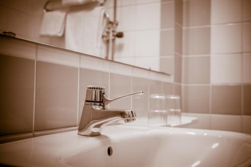 ein Waschbecken mit einem Wasserhahn und einem Spiegel in der Unterkunft Hotell Nivå in Boden