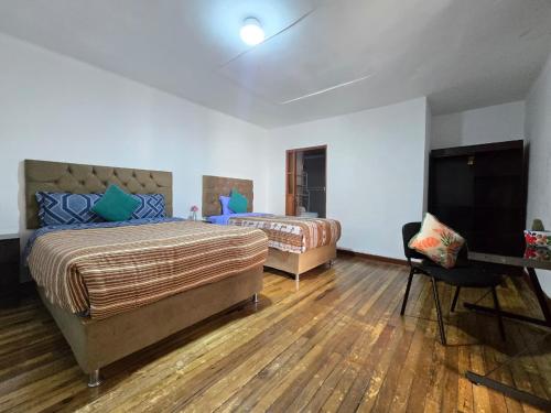 a bedroom with two beds and a flat screen tv at Magnolia Andina Hotel in Cusco