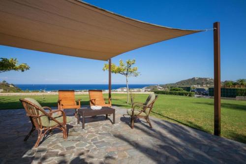 a group of chairs and a table under a canopy at Villa Leyland in Faliraki