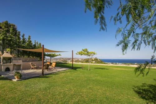 a backyard with a gazebo and the ocean at Villa Leyland in Faliraki