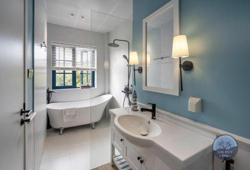a white bathroom with a tub and a sink at CASA Villa NOVAWORLD Phan Thiet in Phan Thiet