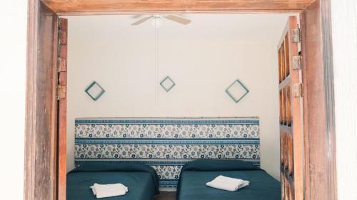 a room with two beds and a ceiling fan at Casona Luciérnaga-Casa de Huéspedes Centro de León, Poliforum in León