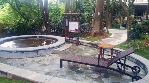 a bench sitting next to a pond in a park at Dongguan Richwood Garden Hotel in Dongguan
