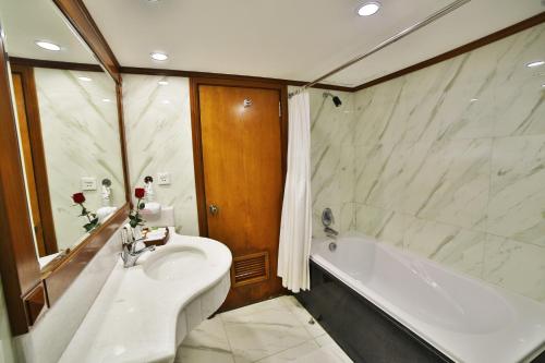 a bathroom with a tub and a toilet and a sink at Sunny Hotel 1 in Hanoi