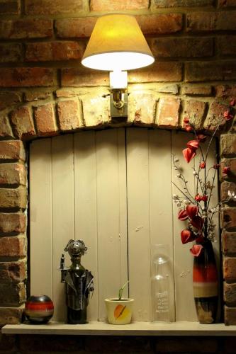 a light on a shelf with a lamp and flowers at Oliver Twist Country Inn in Wisbech